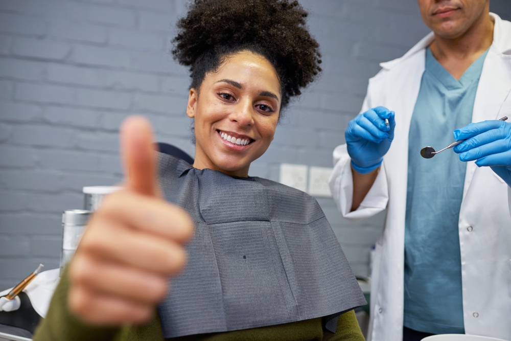 A smiling patient gives a thumbs-up while seated in the dental chair, expressing confidence and satisfaction with her orthodontic care – Orthodontist San Gabriel