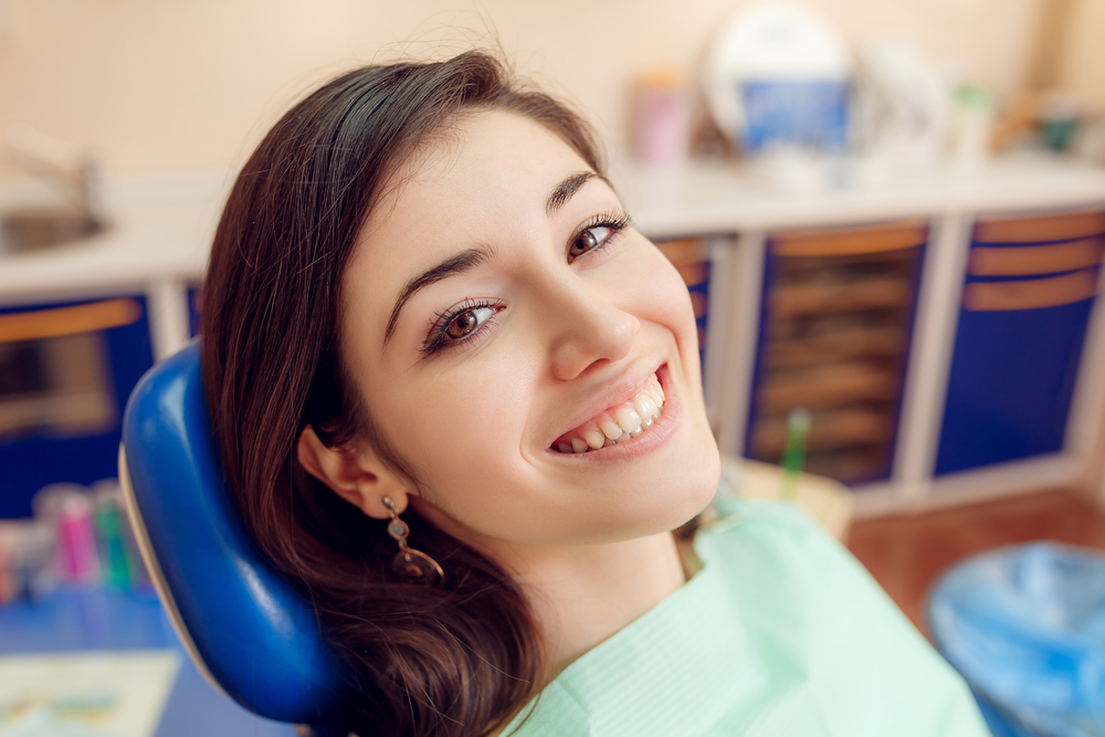 Happy Patient in Dental Chair – Orthodontist Pasadena A woman relaxes in a dental chair with a bright, healthy smile, reflecting positive orthodontic and dental care results – Orthodontist Pasadena.
